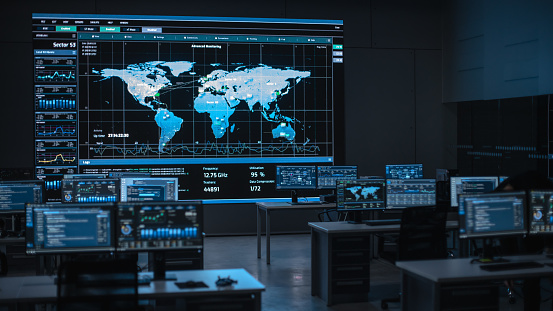 Shot of a Big Empty Data Monitoring Center with Global Map on a Big Digital Screen. Center of Live Ananlysis Financial Stock Market Trading Info and Big Data.