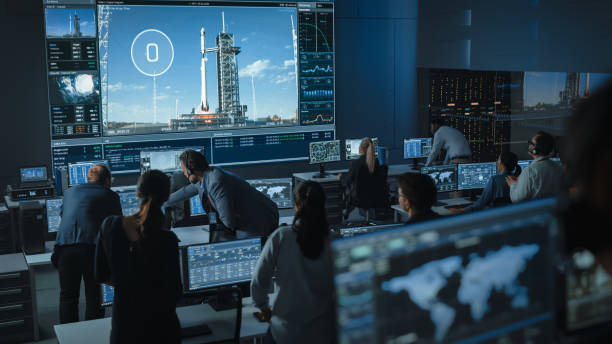 istock Flight Director Counts Down the Seconds Before Space Rocket Launch. Start. Team in Mission Control Witness Successful Lift Off. Flight Control Employees Sit in Front of Computers, Monitor the Mission. 1328842101