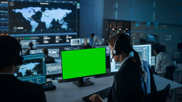 istock Green Screen Horizontal Mock Up on a Computer Display Used by a Female Technical Client Support Specialist. Team of Engineers Work in Control and Monitoring Room with Displays with Big Data. 1328842138