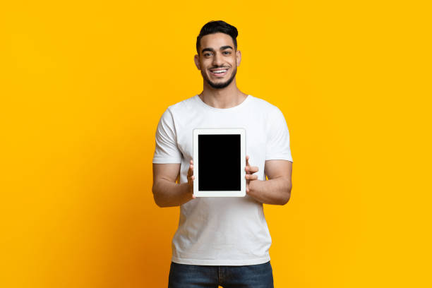istock Cheerful arab guy showing digital tablet with blank screen 1328843448