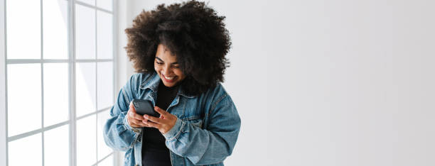 femme attrayante textos sur téléphone mobile - only young women photos photos et images de collection