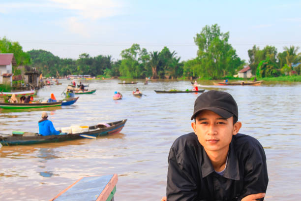 istock young man at boat enjoying a floating market 1328848292
