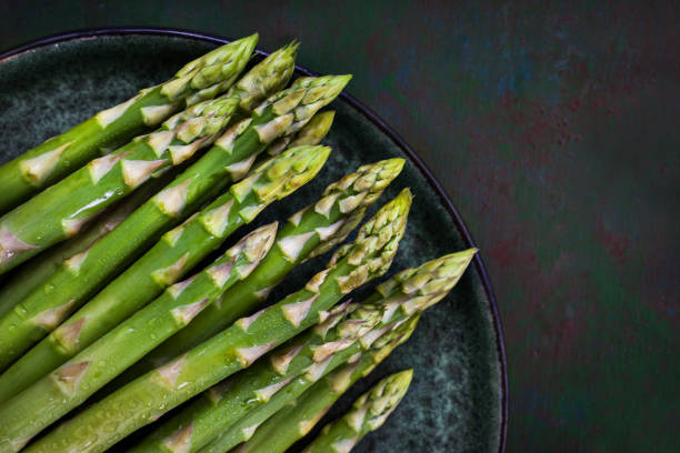 istock Raw fresh asparagus on rustic green background 1328850702