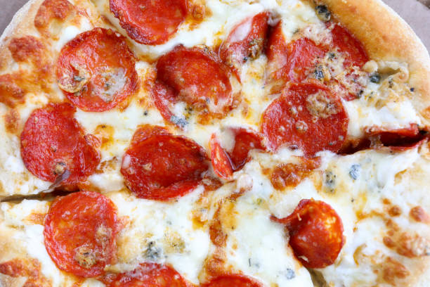 Fresh baked pizza with crusty cheese and hot tasty pepperoni ready to eat
