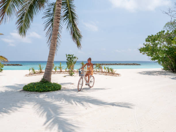 istock young woman riding bicycle on tropical beach 1328853636