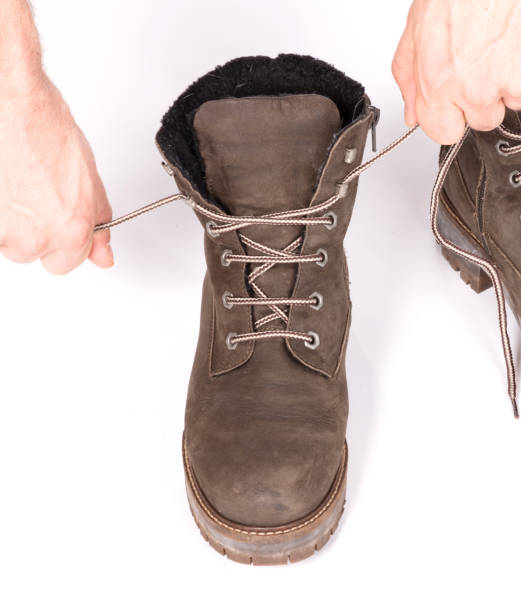 istock Tying laces of a hiking boot, isolated on white 1328853855
