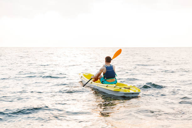 istock Handsome man kayaking on lake sea in boat. 1328854955