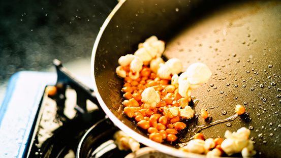 Close up of corn kernels popping while in a hot pan.