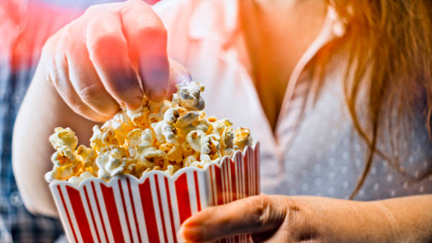 istock Woman taking popcorn from paper carton 1328856049