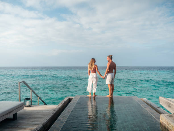 istock Couple walking at the edge of infinity pool 1328856290