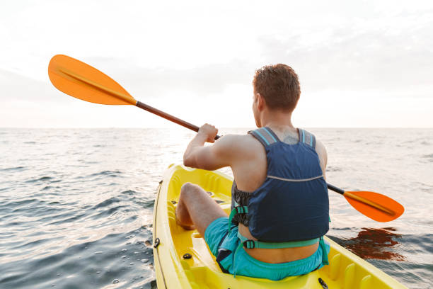 istock Handsome man kayaking on lake sea in boat. 1328856960
