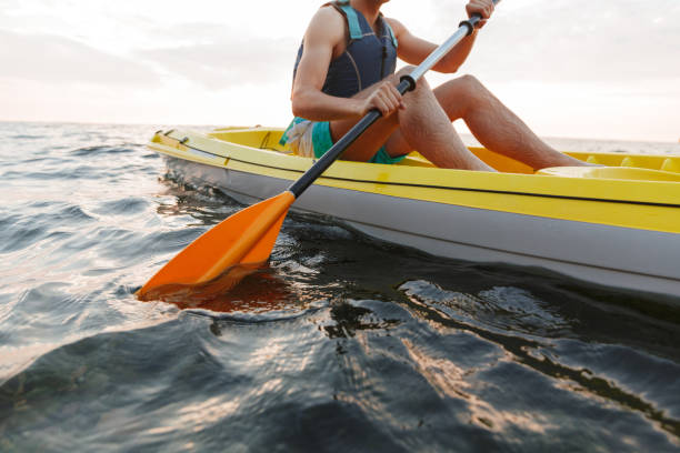 istock Handsome man kayaking on lake sea in boat. 1328857799