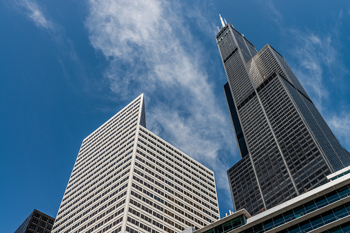 Chicago, IL - May 30, 2019: View from the ground at several skyscrapers including Willis Tower and blue sky between them