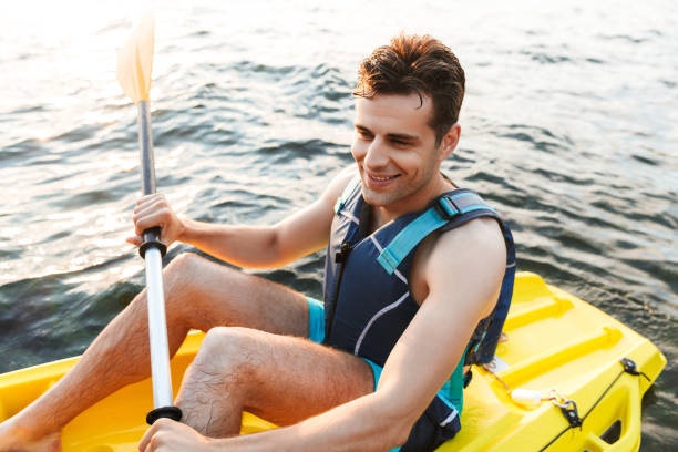 istock Handsome man kayaking on lake sea in boat. 1328858082