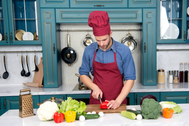 istock Handsome man cooking at home preparing salad 1328859274