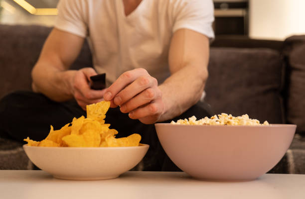 istock Close up of man's hand take chips from bowl 1328861833