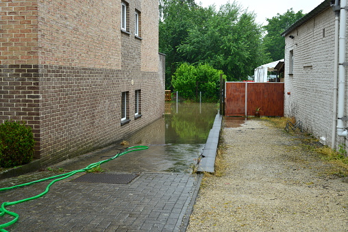 Wilsele, Vlaams-Brabant, Belgium - July 15, 2021: cause of days of rain street flooded habitants can't go to the toilet because they can't flush the water-closet. Street sewers are also full of water.