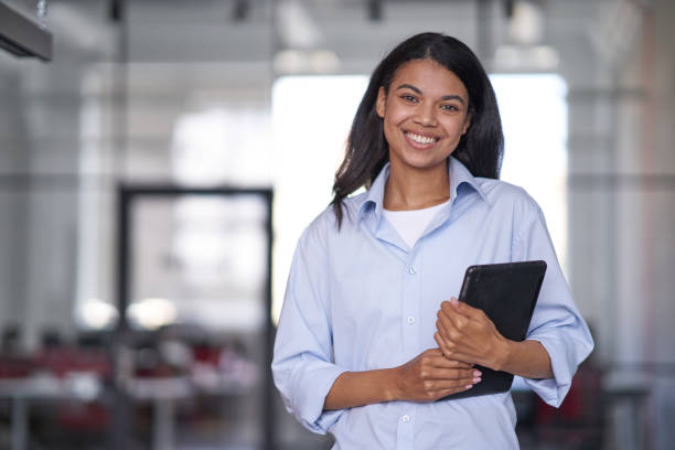 istock Smiling female person working and holding electronic tablet 1328865844