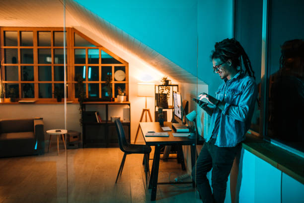 hombre que trabaja con tableta digital en horas extras de oficina - reflection dreadlocks men businessman fotografías e imágenes de stock
