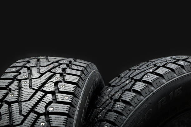 istock Two new tires for winter on a black background 1328873917