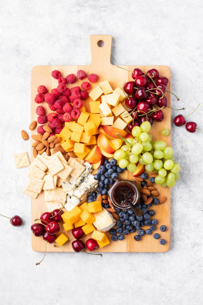 Summer cheese board with season berries, top down view stock photo