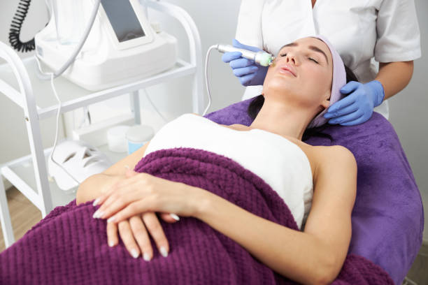 istock Professional cosmetologist is doing procedures for client in light cabinet 1328876074