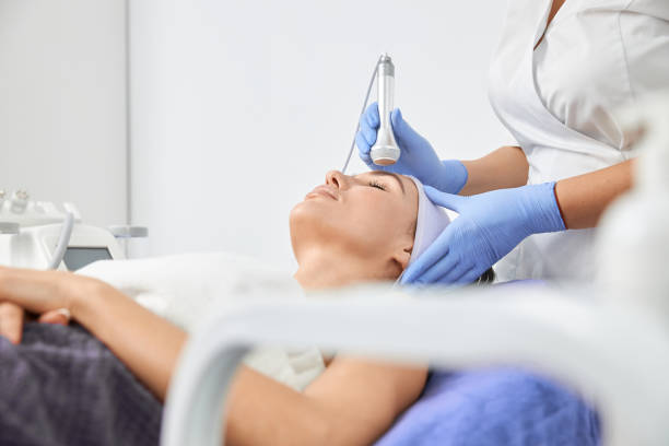 istock Professional cosmetologist is doing procedures for client in light cabinet 1328876122