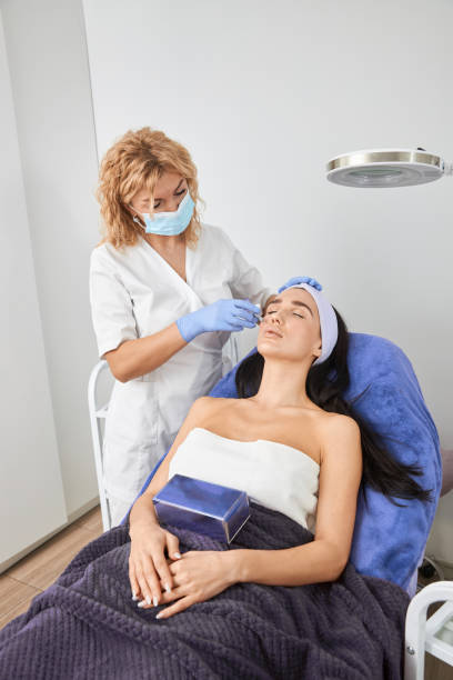 istock Professional cosmetologist is doing procedures for client in light cabinet 1328876145