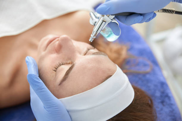 istock Professional cosmetologist is doing procedures for client in light cabinet 1328876188