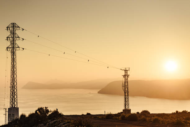 istock High voltage towers on coast at sunset 1328877682
