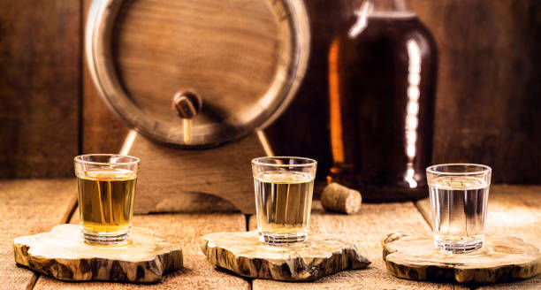 典型的なブラジルのブランデーガラスは、「ピンガ」または「カシャサ」と呼ばれ、サトウキビ製、素朴なまだ設定 - whisky liqueur glass alcohol bottle ストックフォトと画像