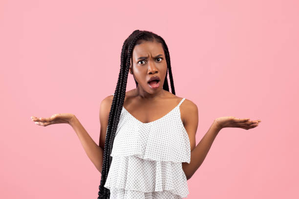 Irritated African American woman showing I DON'T KNOW gesture, shrugging shoulders on pink studio background Irritated African American woman showing I DON'T KNOW gesture, shrugging shoulders on pink studio background. Annoyed black lady cannot understand something, gesturing WTF wtf stock pictures, royalty-free photos & images