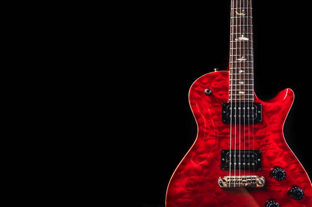 An electric guitar with red shiny body in dark environment and a lot of psace for additional content