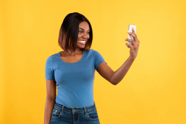 istock Black Woman Making Selfie On Smartphone Posing On Yellow Background 1328878799