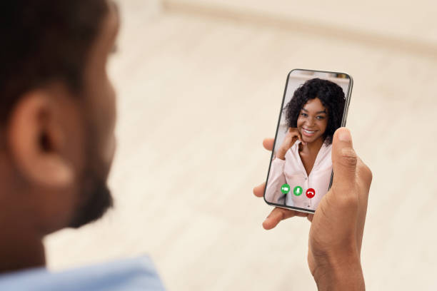 istock African American guy communicating to his girlfriend on video chat, using smartphone for remote conversation, indoors 1328878897