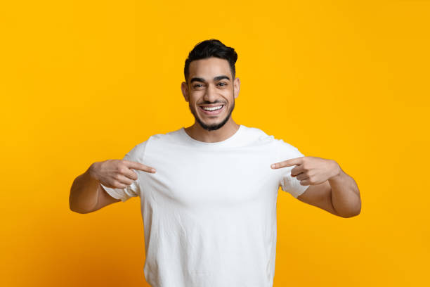 istock Excited arab guy pointing at his blank white t-shirt 1328879071