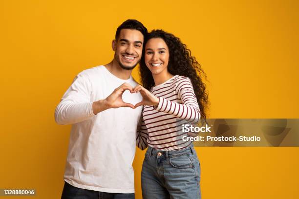 Portrait Of Romantic Arabic Couple Making Heart Gesture With Hands Together Stock Photo - Download Image Now
