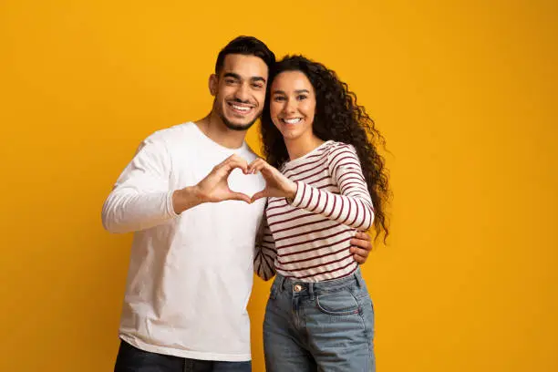 Photo of Portrait Of Romantic Arabic Couple Making Heart Gesture With Hands Together