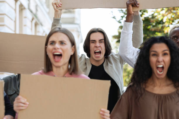 istock Closeup of furious multiracial protestors with empty placards 1328880106