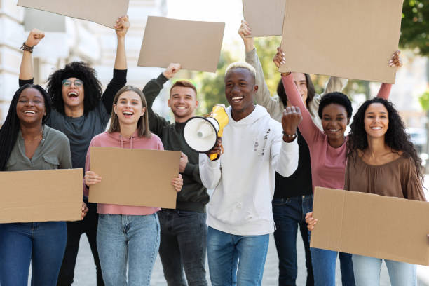 istock Motivated black man with loudspeaker over crowd with empty placards 1328880153