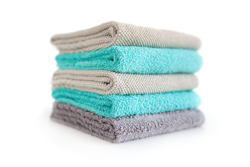 Stack of terry towels of different colors isolated on white background