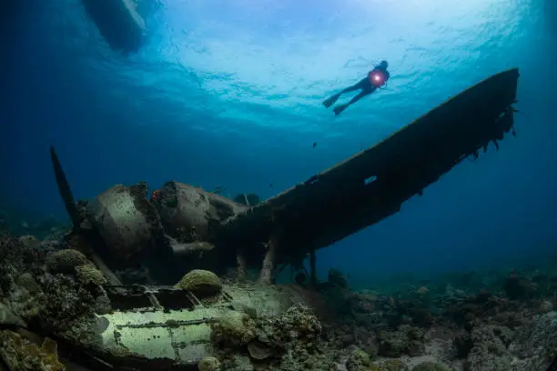 Image with a female diver, a boat and the navy floatplane, an Aichi E13A1-1 or Jake type reconnaissance seaplane. It's one of the most intact wrecks in Micronesia, resting at 45 feet (15m) in Koror, Palau - Micronesia