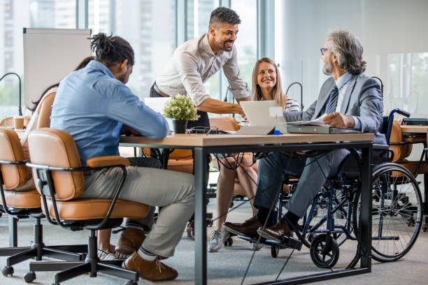istock A man in a wheelchair is working in a bright office. 1328881610
