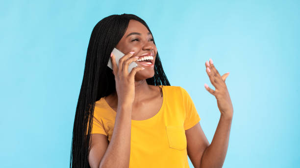 istock Joyful African Woman Talking On Phone Posing Over Blue Background 1328882894