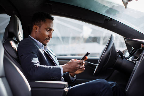 istock African man driving car and using modern smartphone 1328882998