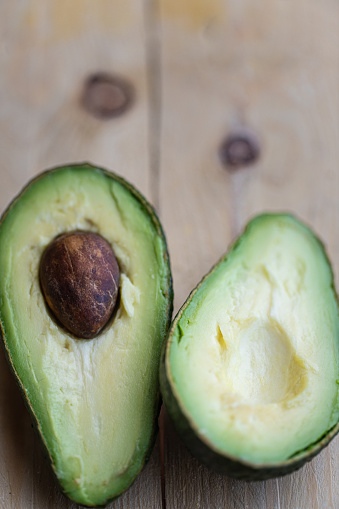 Photo of avocado on wooden background. Photo is taken with natural light.