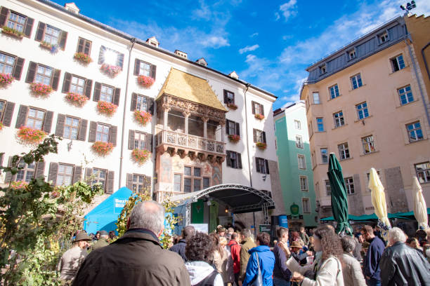 観光客が集まり、有名な黄金時代のダッフルを賞賛しています。 - north tirol austria wall house ストックフォトと画像