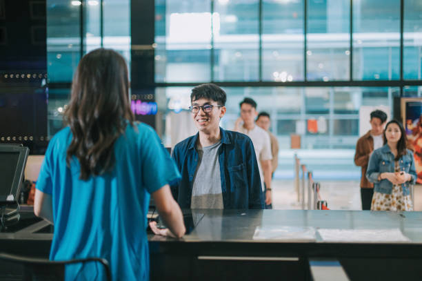 audiencia masculina china asiática en el mostrador de boletos delantero comprando boletos de cine, palomitas de maíz antes de la hora del espectáculo de cine en el cine de cine - cinta para caja registradora fotografías e imágenes de stock