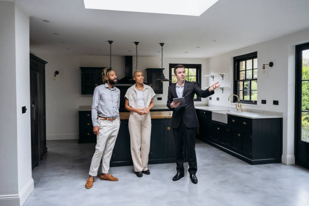 istock Prospective buyers looking at home with real estate agent 1328886164