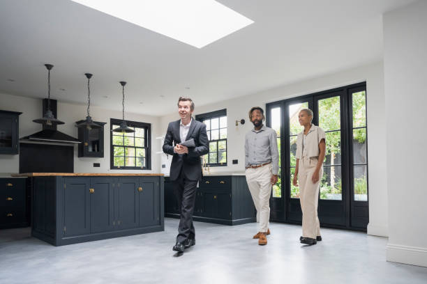 istock Real estate agent and clients walking through luxury home 1328886176
